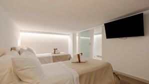 Een hotelkamer met twee bedden, een flatscreen televisie en een groot raam.