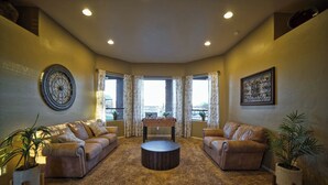 A living room with two leather sofas, a coffee table, and a foosball table.