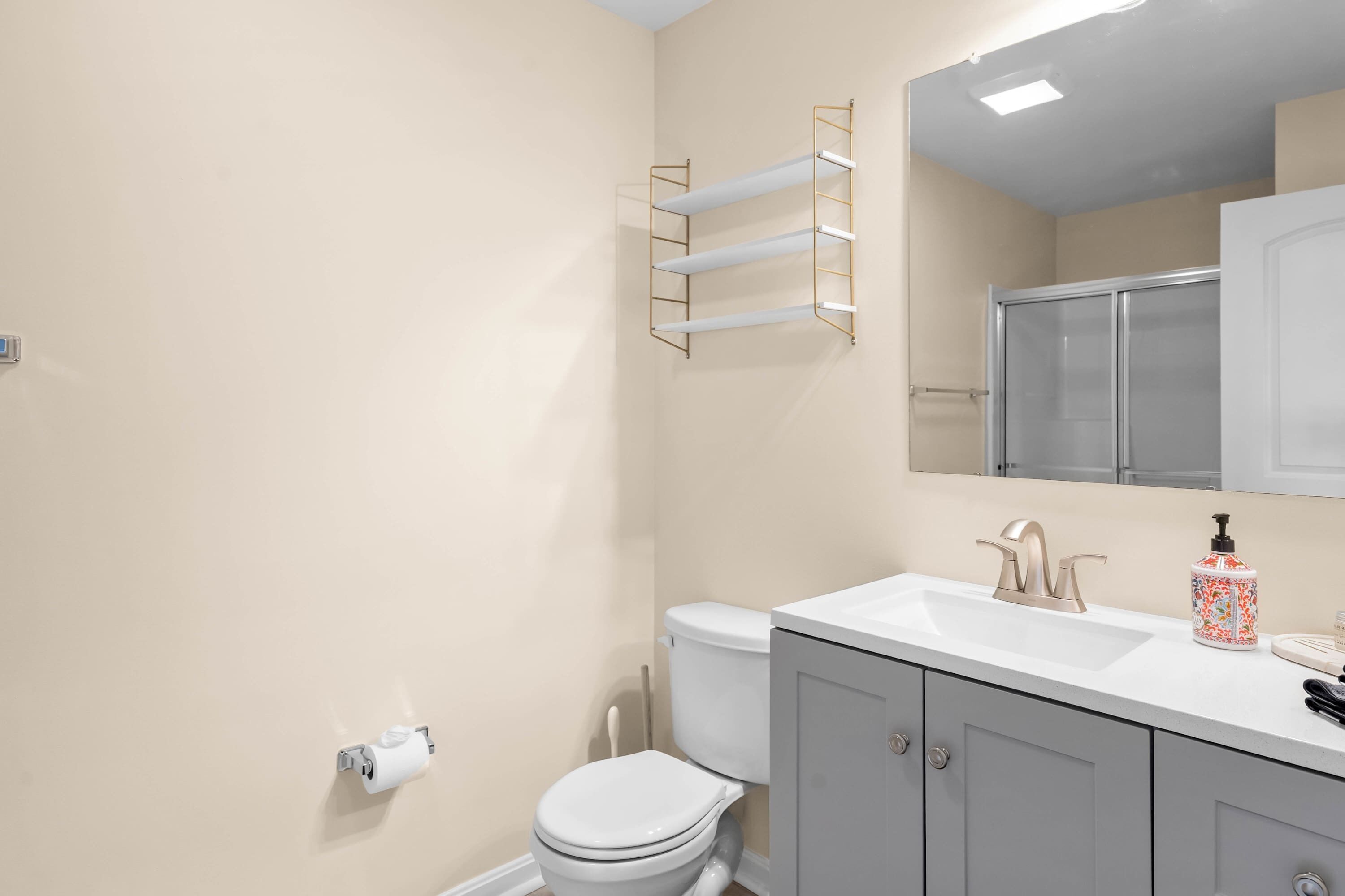 Un baño con inodoro, lavabo y toallero.