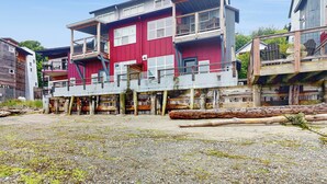 Un immeuble à plusieurs étages, doté d’une façade rouge, de balcons et d’une terrasse en bois.