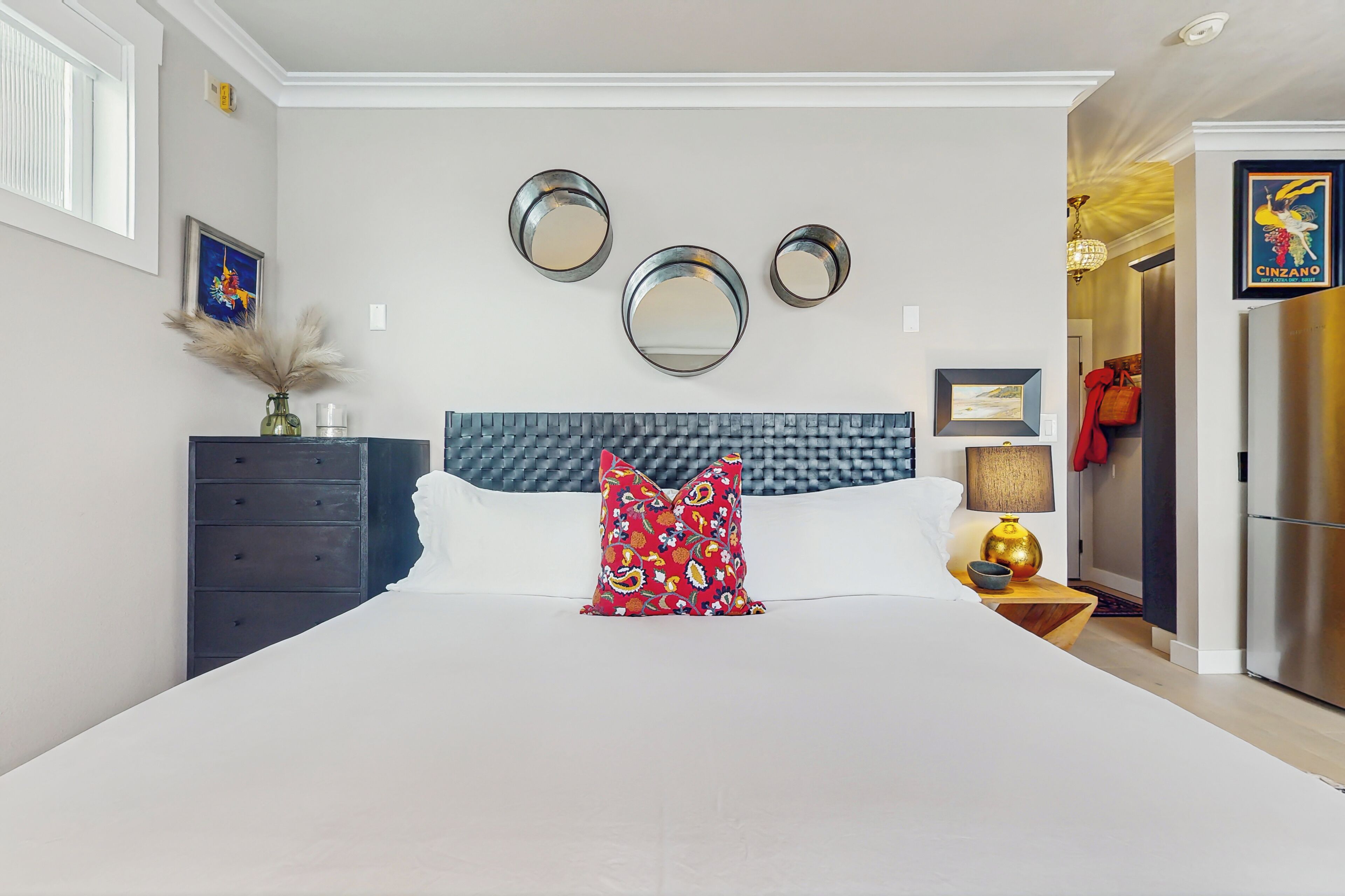 Ein Schlafzimmer mit einem großen Bett, einem Schminktisch, einem Spiegel und einem gerahmten Bild an der Wand.