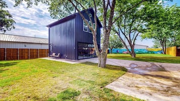 Un bâtiment moderne à l’extérieur sombre, doté de grandes fenêtres et d’une porte de garage bien visible.