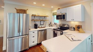 A modern kitchen with stainless steel appliances, white cabinetry, and a central island. - Steps to Riverfront: Dtwn Bluffton Studio! (Bluffton)