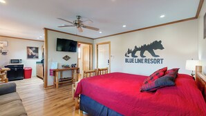 A bedroom with a large bed, a ceiling fan, a TV, and a wall sign reading "Blue Line Resort". - Pet Friendly! Couples Retreat in Southern Illinois (Murphysboro)