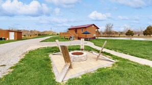 A house with a red roof, a wooden deck, and a stone fire pit in the yard. - Pet Friendly! Couples Retreat in Southern Illinois (Murphysboro)
