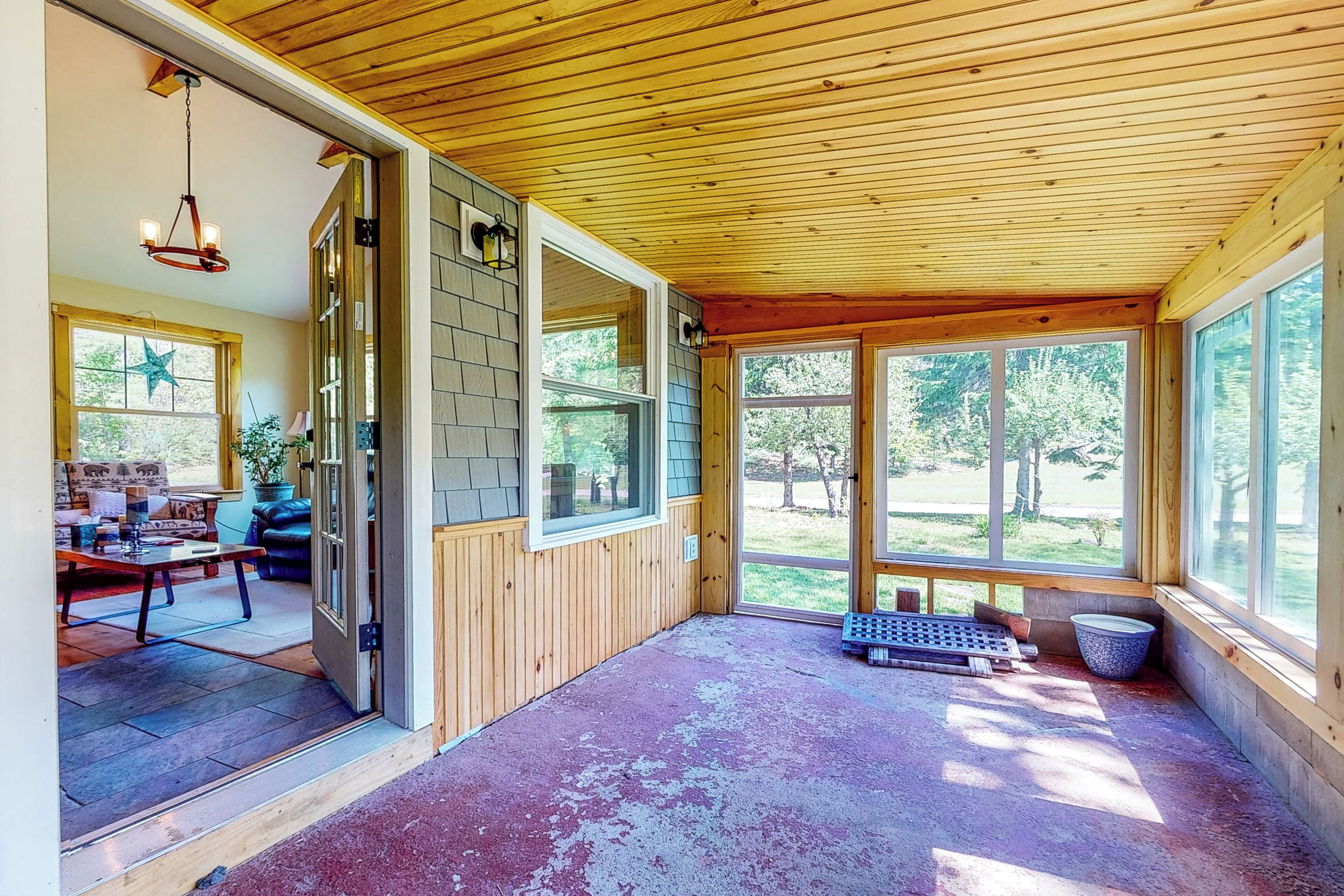 A wooden interior with a large sliding glass door leading to a patio area.