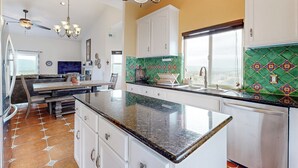 A kitchen with a large island, white cabinets, and a green tiled backsplash. - 3BR Updated Mtn-view Home w/ Hot Tub & Fireplace (Copperopolis)