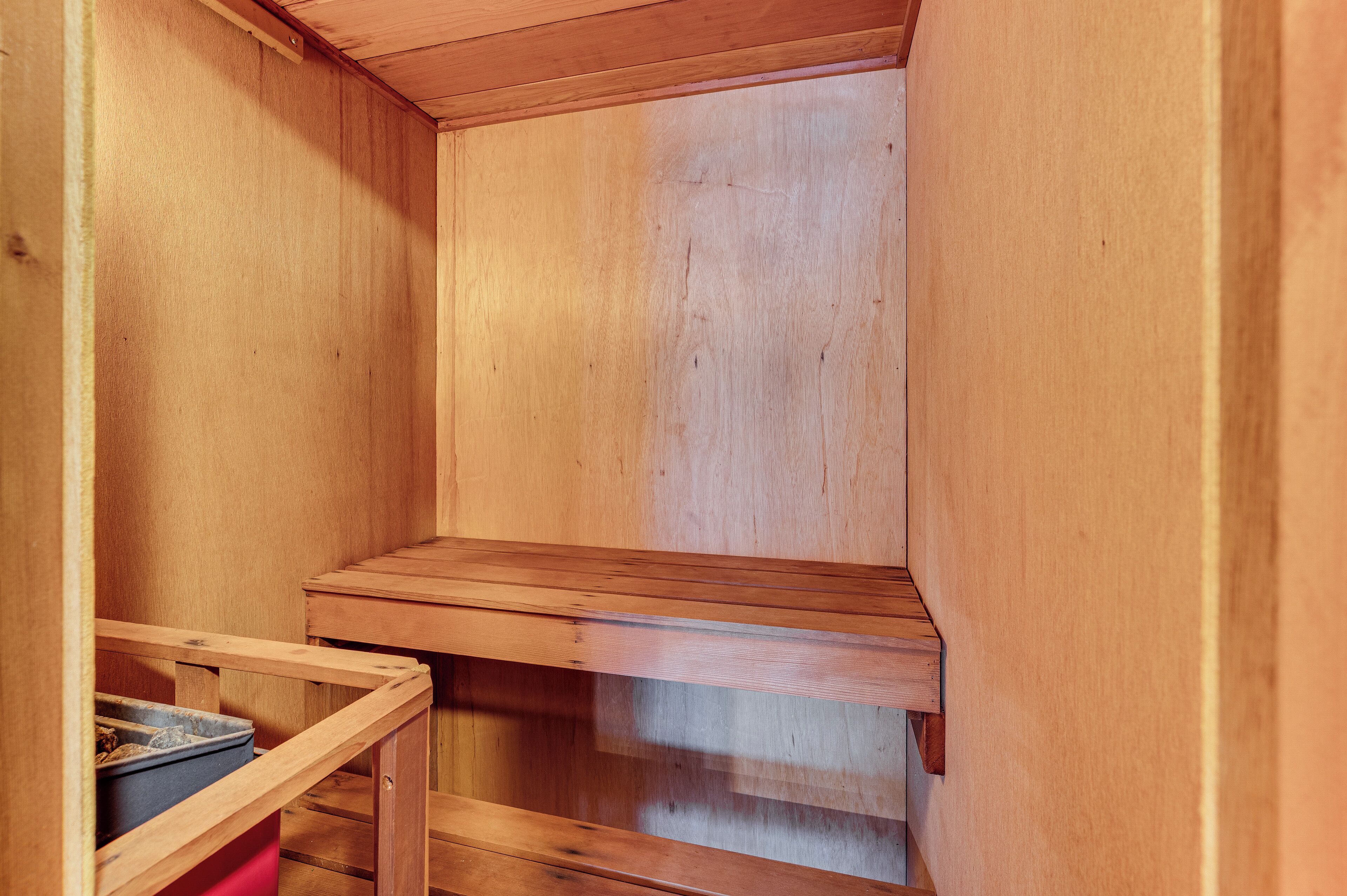 A wooden interior with a built-in bench and a small table.