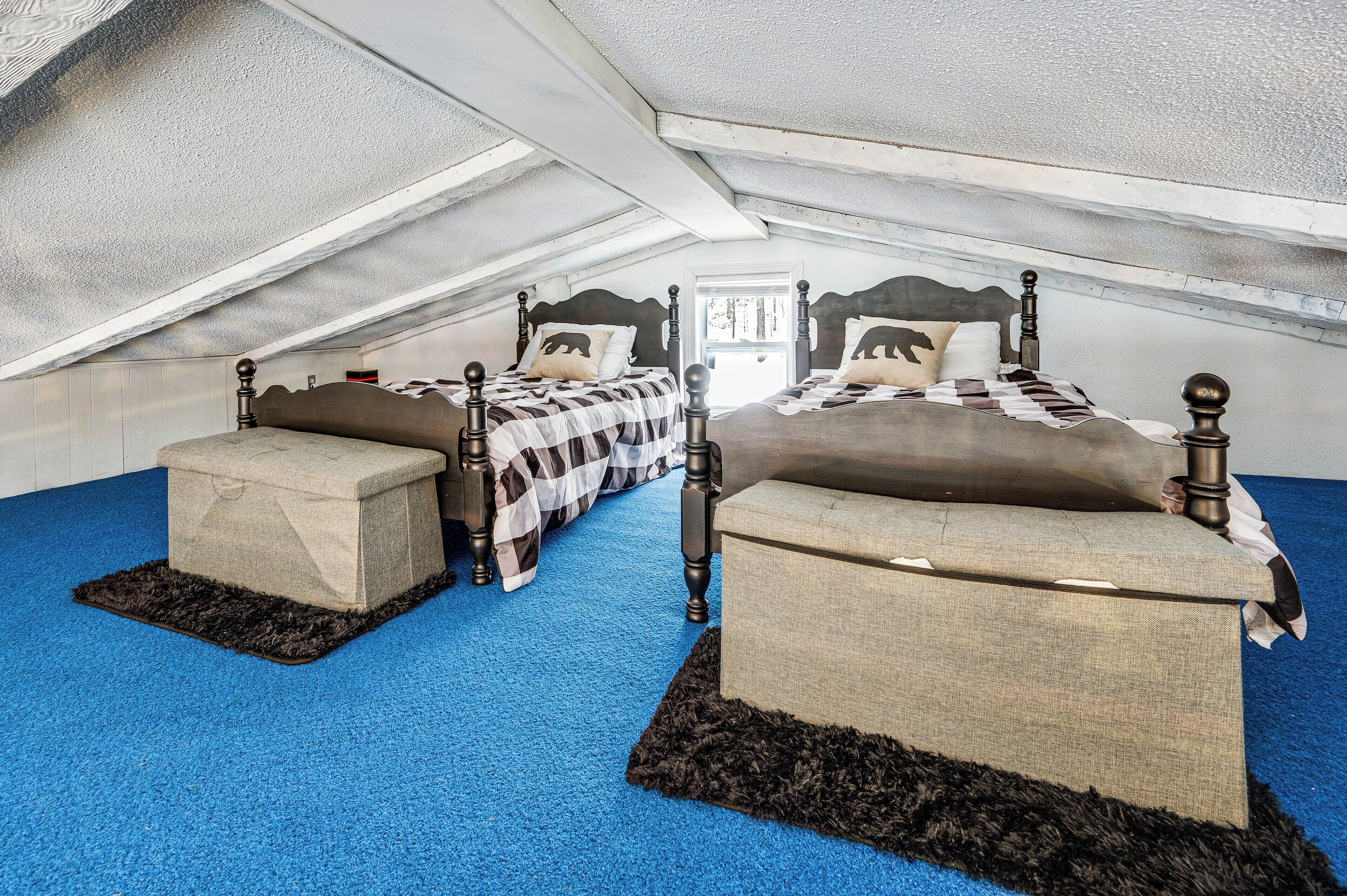 A bedroom with two beds, each with a headboard and footboard, and a window.