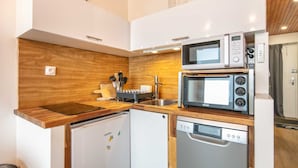 A compact kitchen with a wooden countertop, a built-in microwave, a dishwasher, and a refrigerator. - Nice Apt for 4 pers near the slopes (Chamrousse)