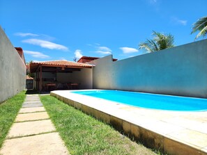 A backyard with a swimming pool, a patio area, and a covered seating space. - Pousada Nossa Casa Barreirinhas (Barreirinhas)