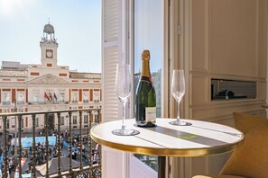 A balcony with a view of a historic building, a bottle of champagne, and two glasses on a table. - La Fonda de los Principes (Madrid)