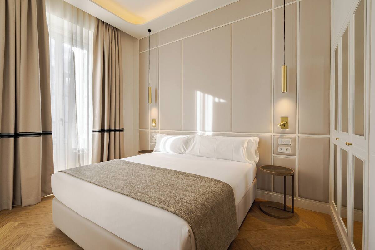 Een hotelkamer met een groot bed, een nachtkastje en een kledingkast.