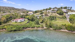 A coastal property with a clear view of the sea, surrounded by lush greenery and hills. - Villa Harmony - Four Bedroom Villa, Sleeps 10 (Les Trois-Îlets)