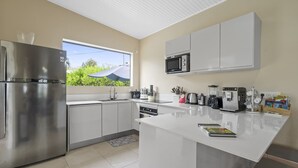 A modern kitchen with stainless steel appliances, a large window, and a central island. - Villa Harmony - Four Bedroom Villa, Sleeps 10 (Les Trois-Îlets)