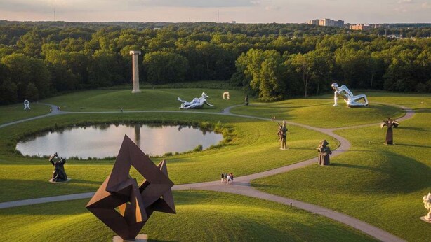 A park with sculptures, a pond, and a distant city skyline. - The Terrace Timber House  For 8 (Hamilton)