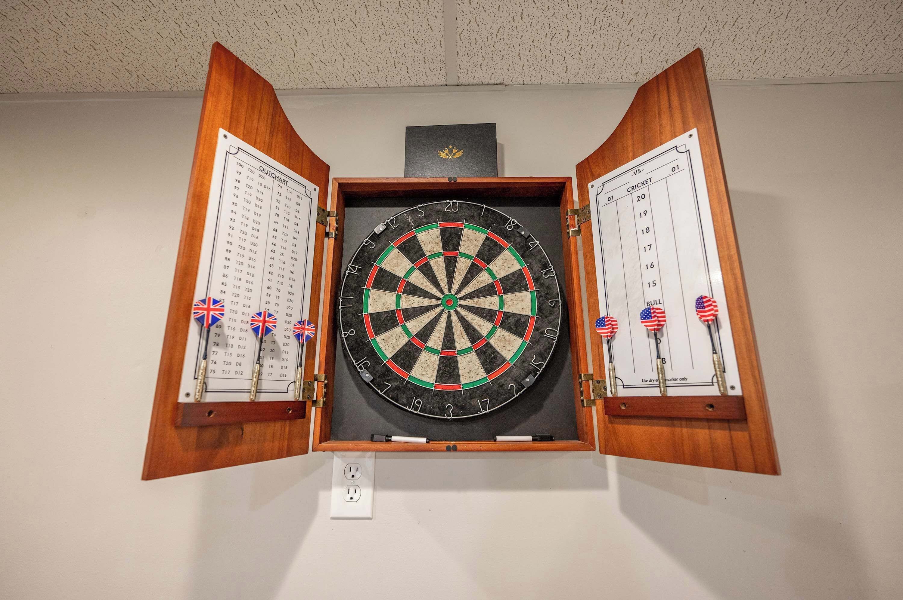 Une cible de fléchettes fixée au mur, avec deux tableaux de pointage de chaque côté.