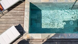 A rectangular swimming pool with clear water, surrounded by stone tiles and wooden decking. - Villa Arlet - Three Bedroom Villa, Sleeps 6 (Les Anses-d'Arlet)