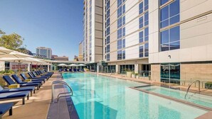 A hotel pool area with lounge chairs and a clear blue pool. - CozySuites at ADELINE (Phoenix)