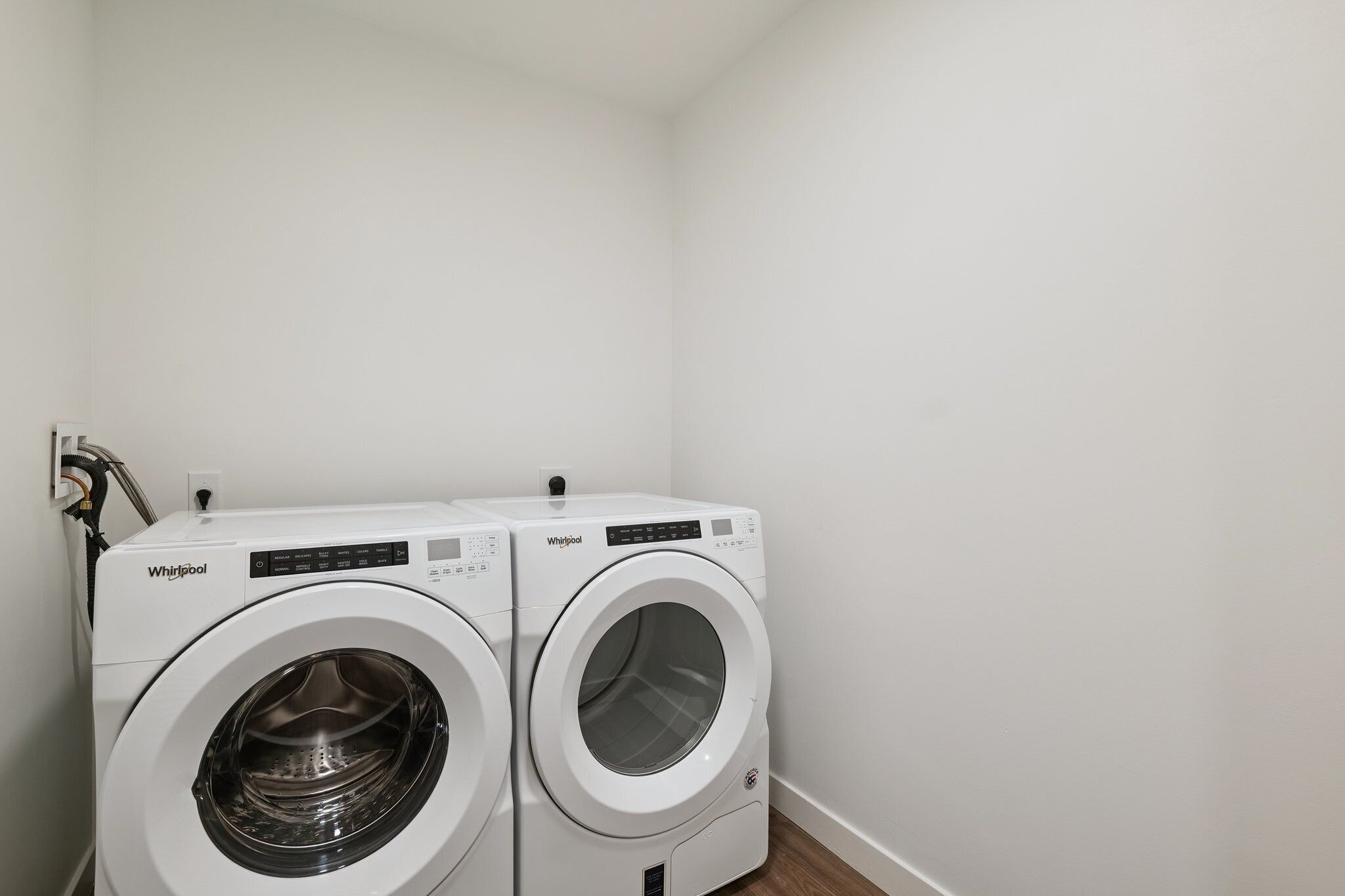 A laundry area with two Whirlpool front-loading washing machines.