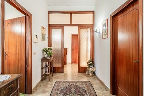 A hallway with wooden doors, a patterned rug, and a small statue. - Peaceful House in the Heart of Tuscany, Near Florence and Siena (Vinci)