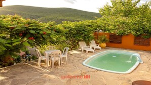 A patio with a swimming pool, outdoor seating, and lush greenery. - Suite Quadrupla em Rio Grande com Vista Montanha (Palmeiras)