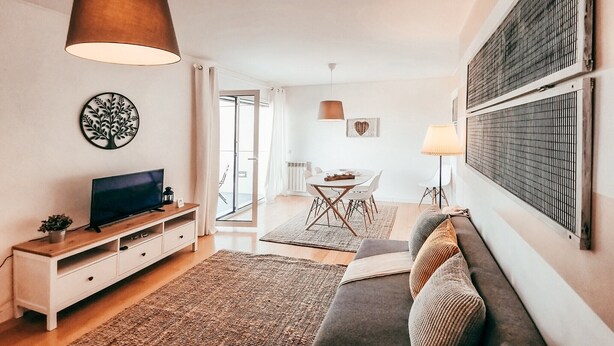 A modern living room with a TV, sofa, and dining area. - Bridge view apartment in Sacavem (Sacavém)