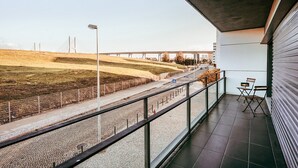 A balcony with a view of a road and bridge, a tiled floor, and two chairs. - Bridge view apartment in Sacavem (Sacavém)
