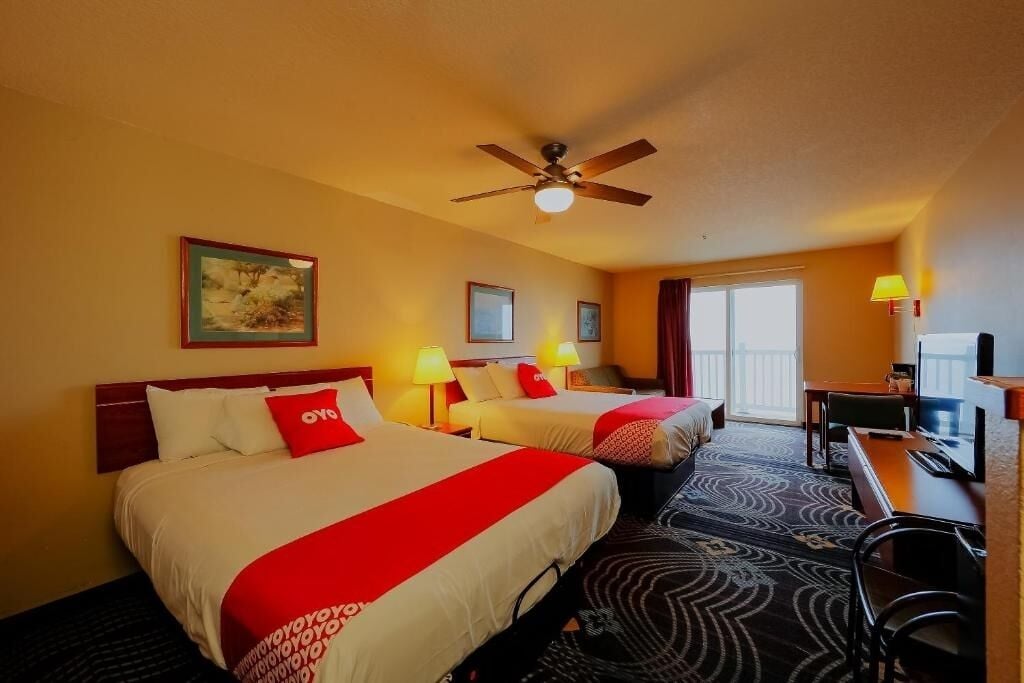 Unwind in a spacious double-queen room with warm lighting.