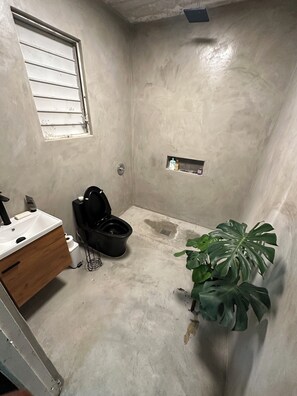A bathroom with a toilet, sink, and a potted plant. - Baby Boy l 1-bedroom apartment with AC in vibrant San Juan (San Juan)