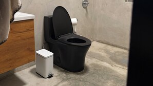 Kylpyhuoneessa on wc, pieni roskakori, ikkuna, jossa on sälekaihtimet, ja puinen taso.