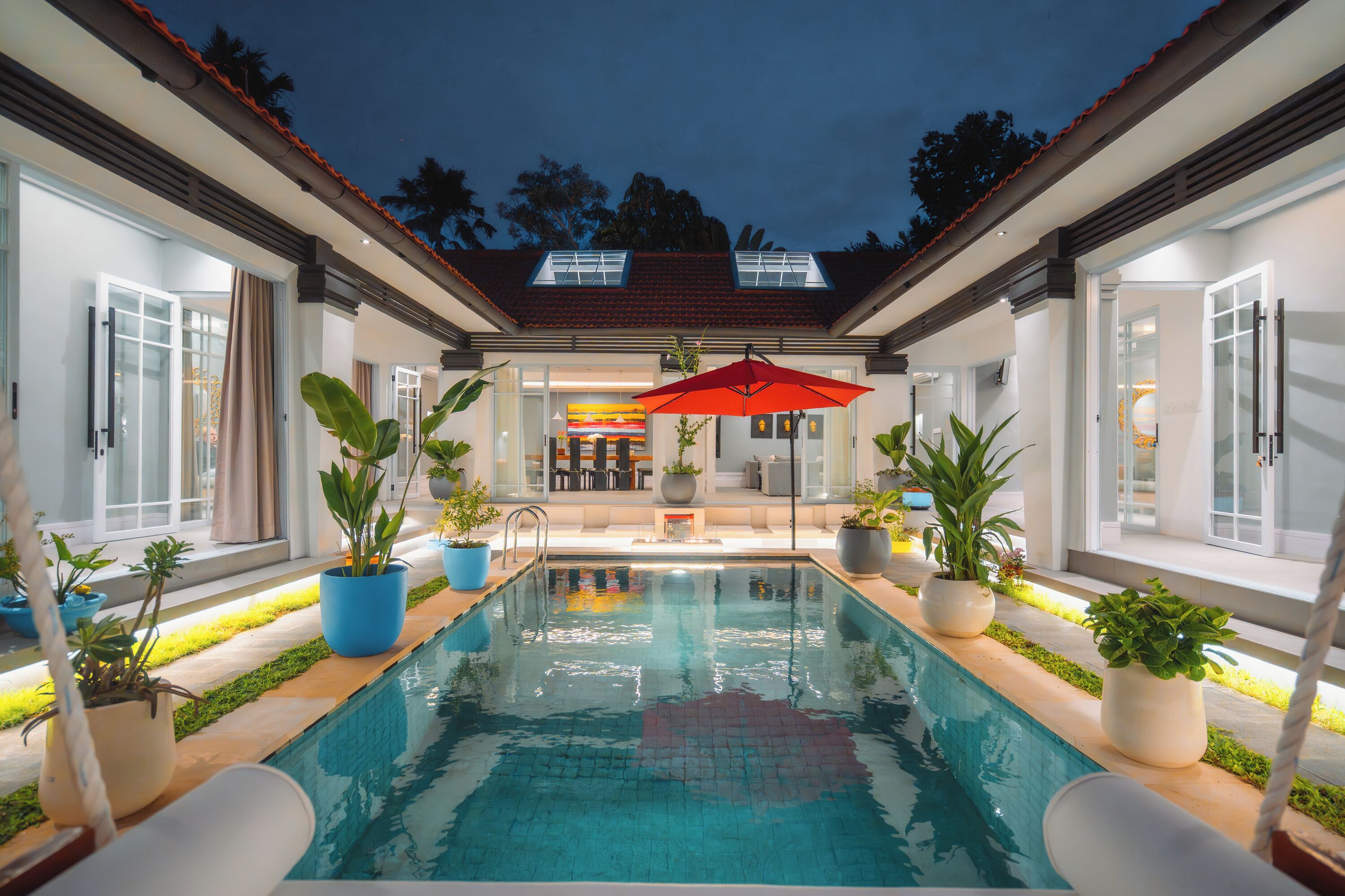 Una piscina al aire libre, sombrillas, sillones reclinables de piscina