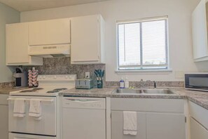 Fridge, dishwasher, coffee/tea maker, cookware/dishes/utensils