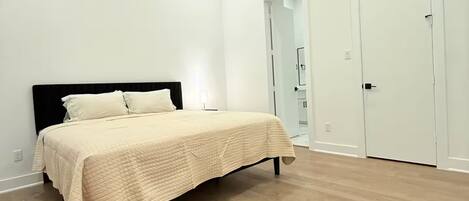 A bedroom with a bed, a ceiling fan, and a door.