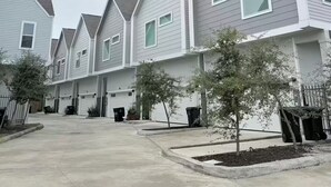 A row of modern, single-story houses with grey siding and pitched roofs. - 3-bedroom house in serene Houston with cool AC for relaxing stays (Houston)