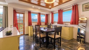 A dining area with a marble floor, wooden ceiling, and red curtains. - Lake Mount (Bhimtal)