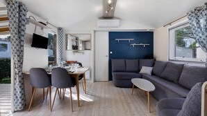 Ein modernes Interieur mit Essbereich, Sofa und Fernseher.