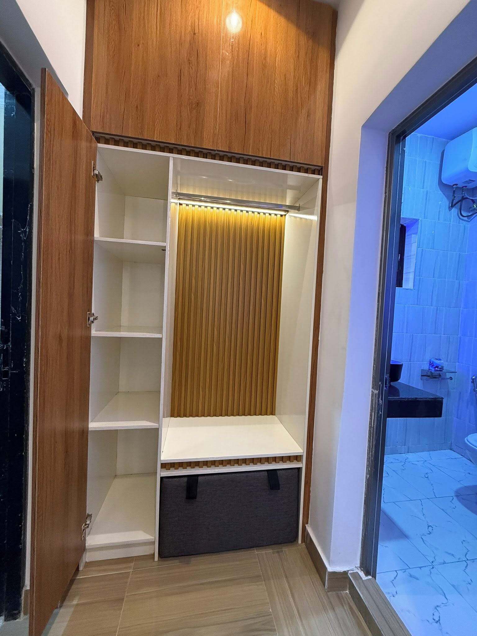 Un dressing avec des portes en bois, un miroir coulissant et des étagères intégrées.
