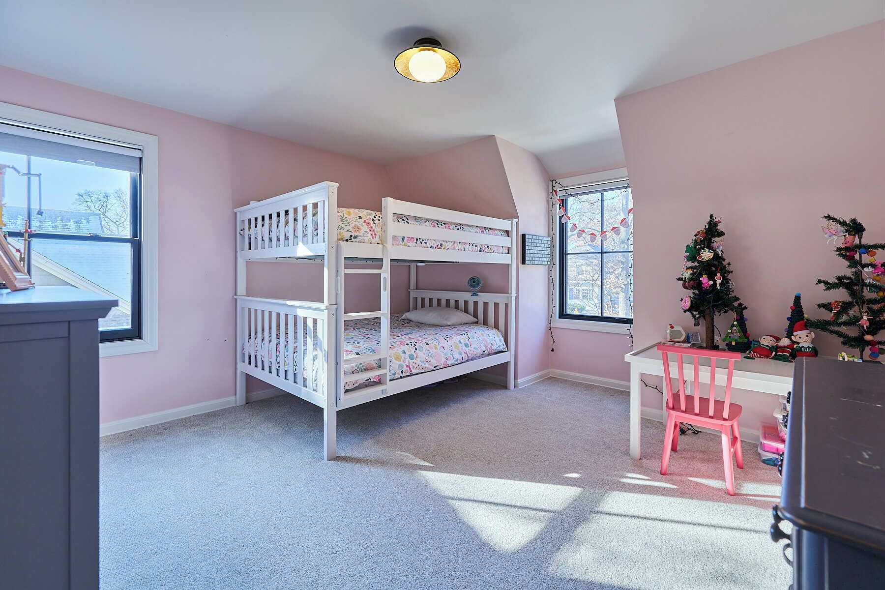 A child's bedroom with bunk beds, a desk, and a chair.