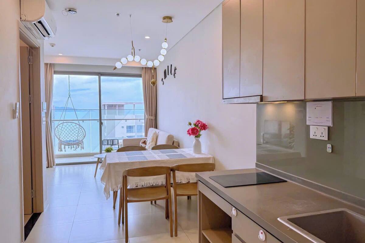 Une chambre d’hôtel moderne avec balcon, coin repas et kitchenette.