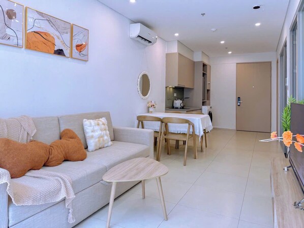 A modern living room with a sofa, coffee table, and dining area.