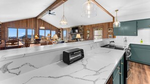 A spacious kitchen with a marble countertop, a built-in toaster, and wooden cabinets. - Tiger Ridge, Single Level w/ Stunning Mtn Views (Highlands)