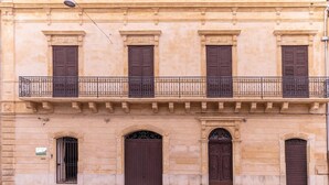 A building with a balcony, four windows, and two doors. - Sinatra Suite Apartment with Private Terrace, Wi-Fi and Air Conditioning (Ispica)