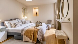 A bedroom with a bed, bedside tables, a bench, a chair, a mirror, and a shelf. - Sinatra Suite Apartment with Private Terrace, Wi-Fi and Air Conditioning (Ispica)
