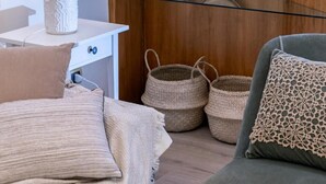A modern room with a glass shelf displaying decorative plates, a white lamp, and woven baskets. - Sinatra Suite Apartment with Private Terrace, Wi-Fi and Air Conditioning (Ispica)