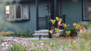 A house with a front porch, steps, and a small garden with pink flowers. - Larkspire I Sleepy Hollow Lake I Beach & Firepit (Athens)