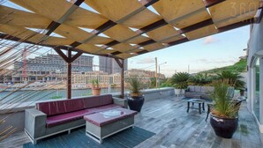A rooftop terrace with a wooden pergola, seating area, and potted plants. - Sea-View Terrace Maisonette, steps from Paceville! (Swieqi)