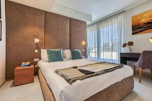 A modern hotel room with a large bed, a desk, and a view of the outdoors. - Elegant City Living with Terrace, Mercury Suites! (St. Julian`s)
