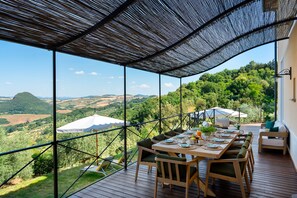 A terrace with a table set for dining, overlooking a scenic landscape. - Villa Francesca 10, Emma Villas (Volterra)