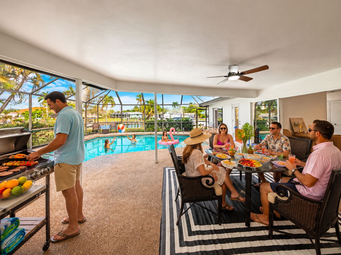 An outdoor pool area with a grill, dining table, and chairs.